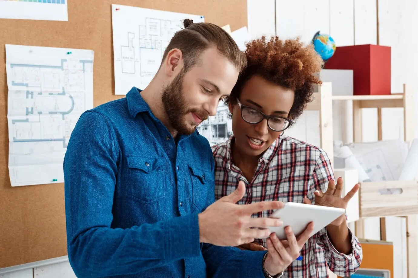Kollegen betrachten ein Tablet und besprechen neue Ideen.