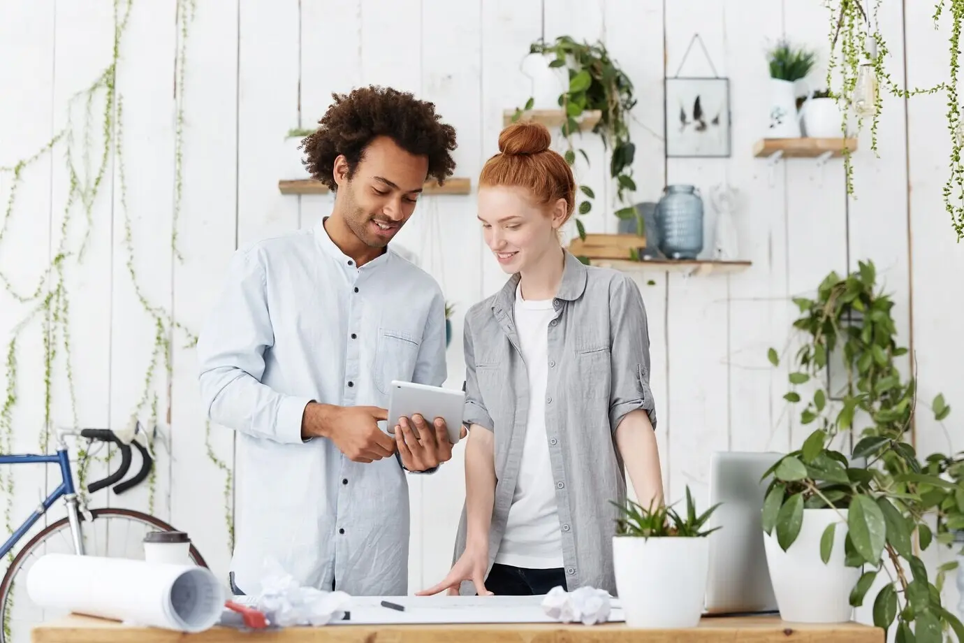 Porträt zweier kreativer Mitarbeiter, die gemeinsam Blaupausen anfertigen.